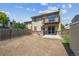 Backyard exterior view of the home featuring a deck, patio, wood fence, and lawn at 12702 Fairfax St, Thornton, CO 80241