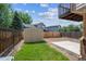 Backyard featuring a storage shed, wood fence, green grass and a concrete slab perfect for entertaining at 12702 Fairfax St, Thornton, CO 80241