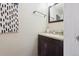 Charming half-bathroom featuring a stylish vanity with a dark wood cabinet and neutral countertop at 12702 Fairfax St, Thornton, CO 80241