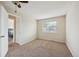 Comfortable bedroom with neutral carpet, a window, and a glimpse into an adjacent room at 12702 Fairfax St, Thornton, CO 80241
