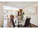 Inviting dining area with a glass table, wood-look floors, and open access to the well-equipped kitchen at 12702 Fairfax St, Thornton, CO 80241