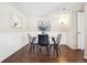 Modern dining area with a glass table, stylish chairs, wood-look floors, and tasteful wall decor at 12702 Fairfax St, Thornton, CO 80241