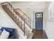 Inviting entryway featuring a carpeted staircase with metal railing and a stylish front door at 12702 Fairfax St, Thornton, CO 80241