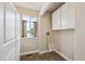 Bright laundry room with ample storage cabinets, a window for natural light, and neutral-toned flooring at 12702 Fairfax St, Thornton, CO 80241