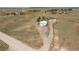 Aerial photograph of a single Gathering residence and detached garage with a long driveway and an open field at 1143 Belgian Trl, Elizabeth, CO 80107