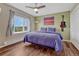 Cozy bedroom with wooden floors, ceiling fan, and a large window offering scenic views at 1143 Belgian Trl, Elizabeth, CO 80107