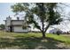 Exterior shot of a charming home with large trees, green lawn, and a detached garage on a large lot at 1143 Belgian Trl, Elizabeth, CO 80107