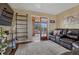 Living room with hardwood floors, dark sofa, sliding glass doors leading to a screened-in porch at 1143 Belgian Trl, Elizabeth, CO 80107