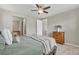 Cozy bedroom featuring a bed with a soft throw, a wooden dresser, and a glimpse into the ensuite bathroom at 540 E Fremont Pl, Centennial, CO 80122