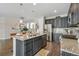 Modern kitchen with a large island, stainless steel appliances, and dark cabinets with a seating area at 540 E Fremont Pl, Centennial, CO 80122
