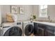 Functional laundry room with modern washer and dryer, storage cabinets, and a sink at 540 E Fremont Pl, Centennial, CO 80122