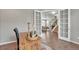 Bright office showcasing a wooden desk, open French doors, and a glimpse into the stylishly decorated living room and staircase at 540 E Fremont Pl, Centennial, CO 80122
