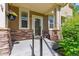 Cozy front porch with stone accents, a hanging flower basket, and a charming entrance to the home at 14247 W 84Th Cir # A, Arvada, CO 80005
