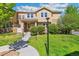 Inviting two-story townhome featuring a landscaped front yard, stone accents, and a charming walkway at 14247 W 84Th Cir # A, Arvada, CO 80005