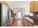 Stylish kitchen with stainless steel appliances, wooden cabinets, and a door leading to outdoor area at 14247 W 84Th Cir # A, Arvada, CO 80005