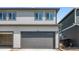 Two-car garage featuring neutral siding, a concrete driveway, and a well-maintained facade at 18724 E 99Th Ave, Commerce City, CO 80022