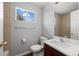 The bathroom is well-lit with a vanity, toilet, mirror, and a window at 10280 W 8Th Ave, Lakewood, CO 80215