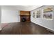 Cozy living room featuring a brick fireplace, wood floors, and abundant natural light at 10280 W 8Th Ave, Lakewood, CO 80215