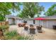 Backyard with patio seating under a red umbrella and a detached garage on a concrete surface at 4057 Bryant St, Denver, CO 80211