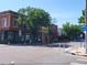 Street view shows local businesses on a street corner, including street signs and mature trees at 4057 Bryant St, Denver, CO 80211
