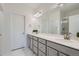 Bright bathroom features double sinks, a large mirror, modern vanity, and white cabinets at 8376 Lorenzo Ln # C, Littleton, CO 80129