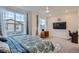 Cozy bedroom with large windows, TV, ceiling fan, and modern decor at 8376 Lorenzo Ln # C, Littleton, CO 80129