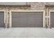 Exterior image of the garage door and driveway, including the exterior water spigot at 8376 Lorenzo Ln # C, Littleton, CO 80129
