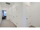 Hallway view featuring multiple closets, carpet floors, and white-colored walls and doors at 8376 Lorenzo Ln # C, Littleton, CO 80129