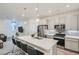 Open kitchen with modern appliances and seating overlooking living area at 8376 Lorenzo Ln # C, Littleton, CO 80129