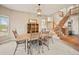 Bright dining room with a large window, wooden table and chairs, and access to the staircase at 10170 E 151St Ct, Brighton, CO 80602