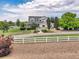 Lovely two-story home with a covered porch, mature trees and surrounded by white fencing at 10170 E 151St Ct, Brighton, CO 80602