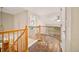 Bright hallway features wood railing, unique floor design, and views through a window at 10170 E 151St Ct, Brighton, CO 80602