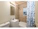 The bathroom features tiled walls, a window, and a shower/tub combo at 1161 S Perry St, Denver, CO 80219