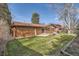 Spacious backyard with a lush lawn, mature trees, and a concrete patio, perfect for outdoor entertaining at 8122 W Woodard Dr, Lakewood, CO 80227