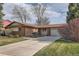 Exterior of a charming single-story brick house featuring a two-car garage and well-maintained landscaping at 8122 W Woodard Dr, Lakewood, CO 80227
