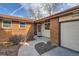 Close-up of a well-maintained house featuring a brick facade, cozy entryway, and two-car garage at 8122 W Woodard Dr, Lakewood, CO 80227