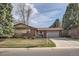 Charming brick home with a well-manicured front yard, mature trees, and an attached two-car garage at 8122 W Woodard Dr, Lakewood, CO 80227