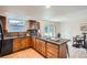 Traditional kitchen with wood cabinets, granite countertops, stainless steel appliances, and tile flooring at 8122 W Woodard Dr, Lakewood, CO 80227