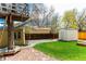 Backyard featuring a treehouse, storage shed, grass, stone path, and mature trees at 2348 Sherman St, Longmont, CO 80501