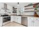 Bright kitchen featuring stainless steel appliances, white cabinetry, and stylish open shelving at 2348 Sherman St, Longmont, CO 80501