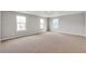 Spacious bedroom features neutral tones, three large windows allowing for natural light, and plush carpeting at 14239 Beebalm Ave, Parker, CO 80134