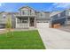 Two-story home with a front porch, stone accents, and a two-car garage on a lush lawn at 14239 Beebalm Ave, Parker, CO 80134