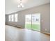 Living room with large windows, a sliding glass door to the backyard, and hardwood floors at 14239 Beebalm Ave, Parker, CO 80134