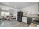 Open kitchen design adjacent to living room, featuring granite countertops and modern black appliances at 772 Lewiston St, Aurora, CO 80011