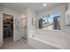 Bright bathroom featuring a soaking tub, walk-in shower, and a spacious walk-in closet with shelving at 11263 Vrain Dr, Westminster, CO 80031