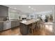Modern kitchen featuring a large island with seating, stainless steel appliances, and hardwood floors at 11263 Vrain Dr, Westminster, CO 80031