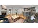 Open concept living room with hardwood floors, a fireplace, and a view into the kitchen at 11263 Vrain Dr, Westminster, CO 80031