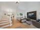 Bright living room with vaulted ceilings, a large entertainment center, and a staircase to the second floor at 11263 Vrain Dr, Westminster, CO 80031