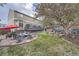 Landscaped backyard featuring stone patio, fire pit, and mature trees at 11710 Crow Hill Dr, Parker, CO 80134