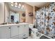Well-lit bathroom featuring a vanity, toilet, and shower with floral curtain at 11710 Crow Hill Dr, Parker, CO 80134